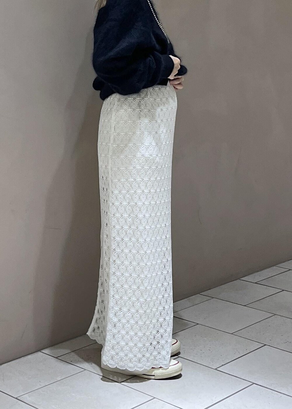 ホワイト系のスカート、ブルー系のニット/セーター、ホワイト系のスラックスを着用したレディースの秋コーディネートの6枚目の写真