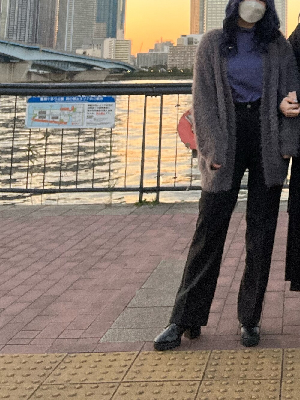 ブルー系のTシャツ/カットソー、グレー系のニット/セーター、ブラック系のパンツを着用したレディースの秋コーディネートの2枚目の写真