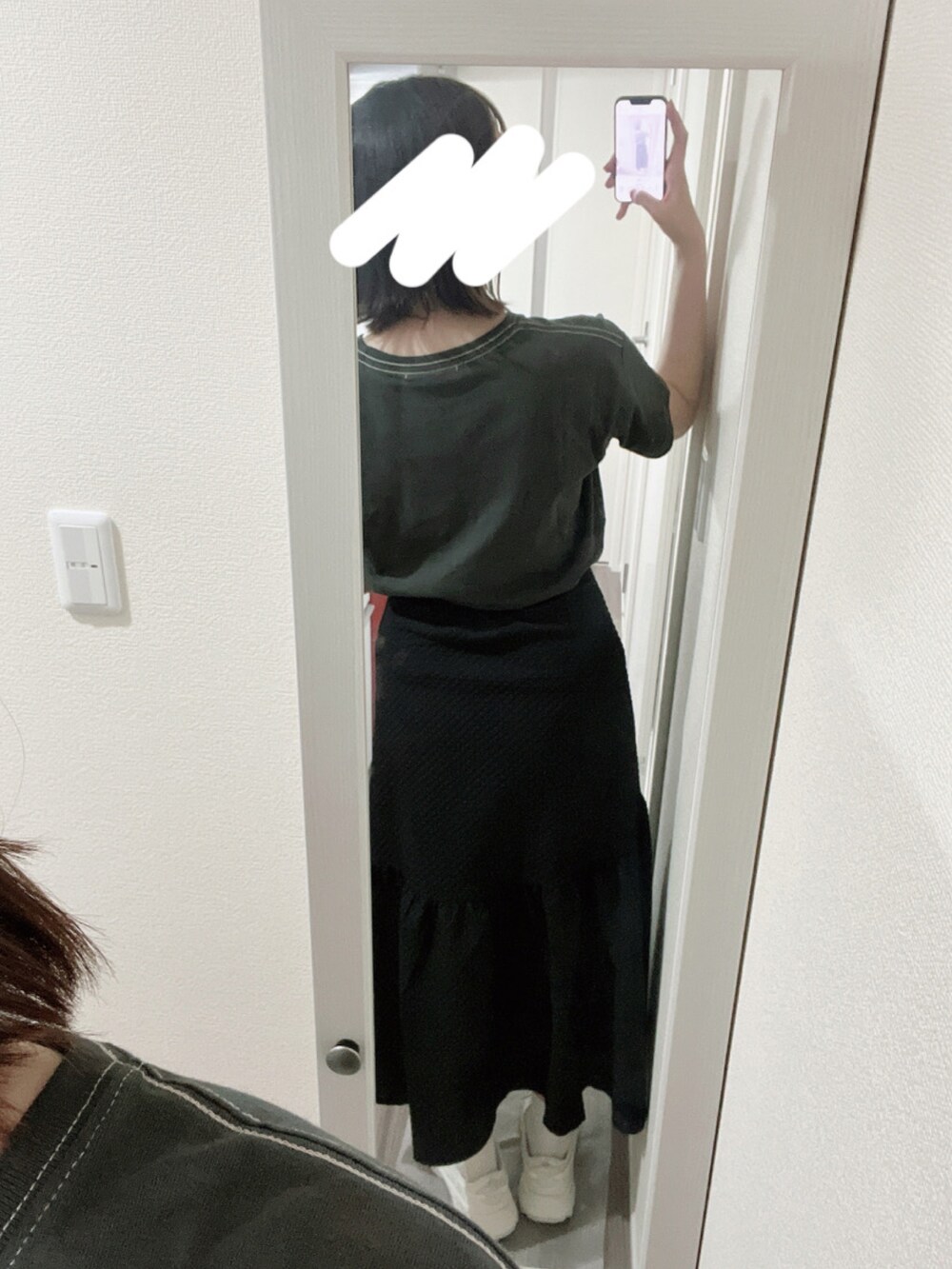 グレー系のTシャツ/カットソー、ブラック系のスカート、ホワイト系のスニーカーを着用したレディースの春コーディネートの2枚目の写真