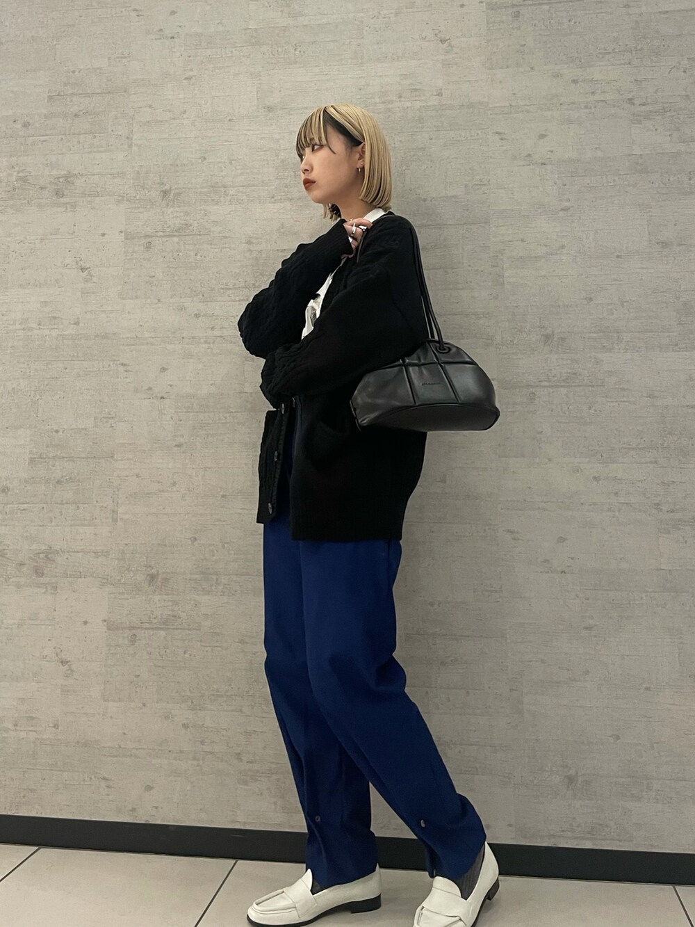 ブラック系のカーディガン/ボレロ、ブラック系のボストンバッグを着用したレディースの冬コーディネートの2枚目の写真