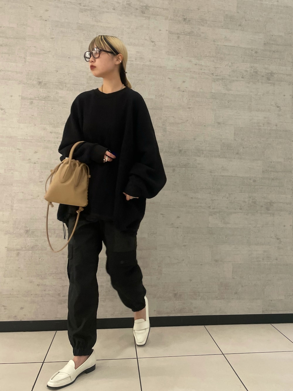 イエロー系のショルダーバッグを着用したレディースの冬コーディネートの2枚目の写真