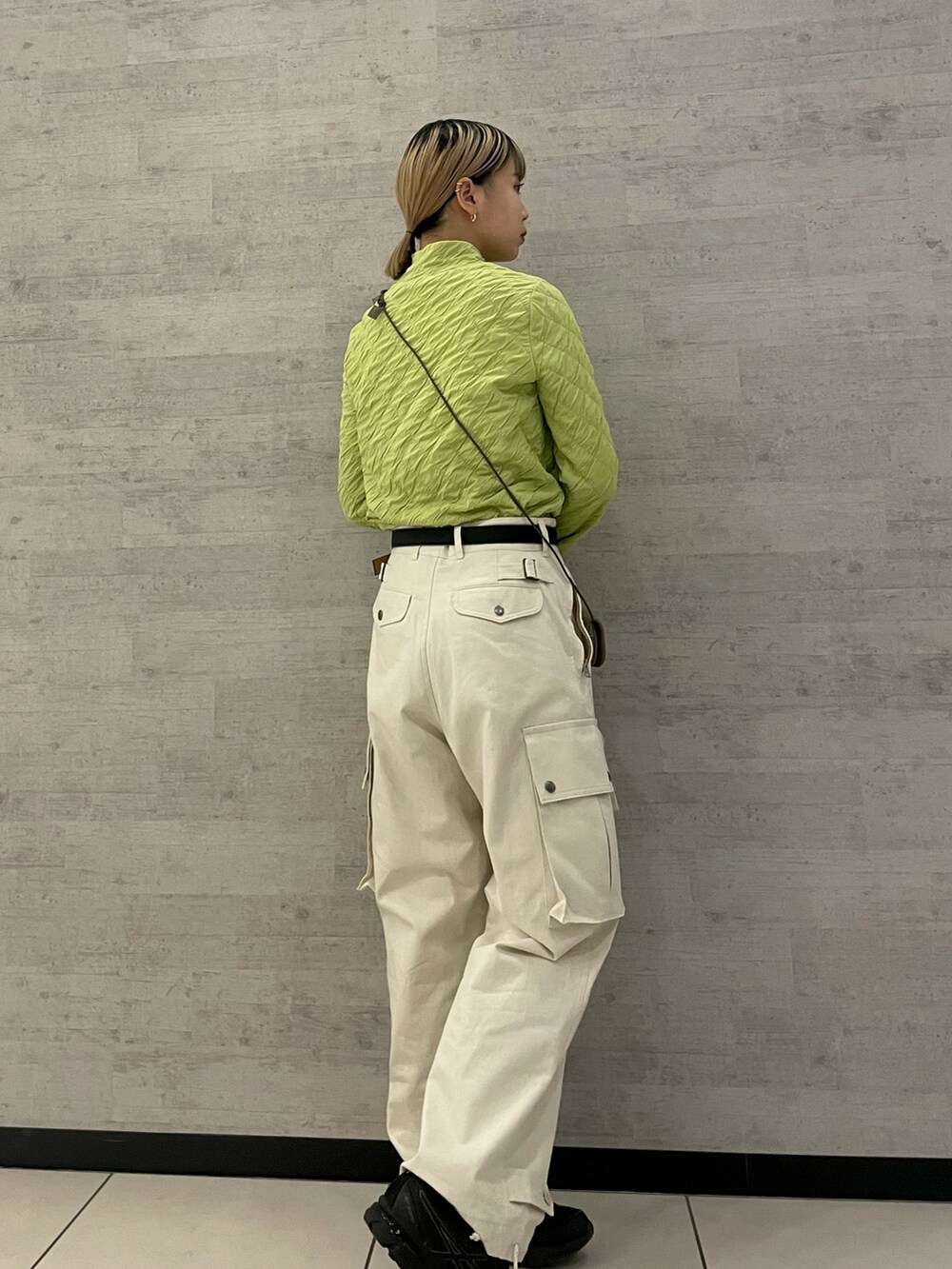 ベージュ系のパンツ、グリーン系のTシャツ/カットソーを着用したレディースの冬コーディネートの2枚目の写真