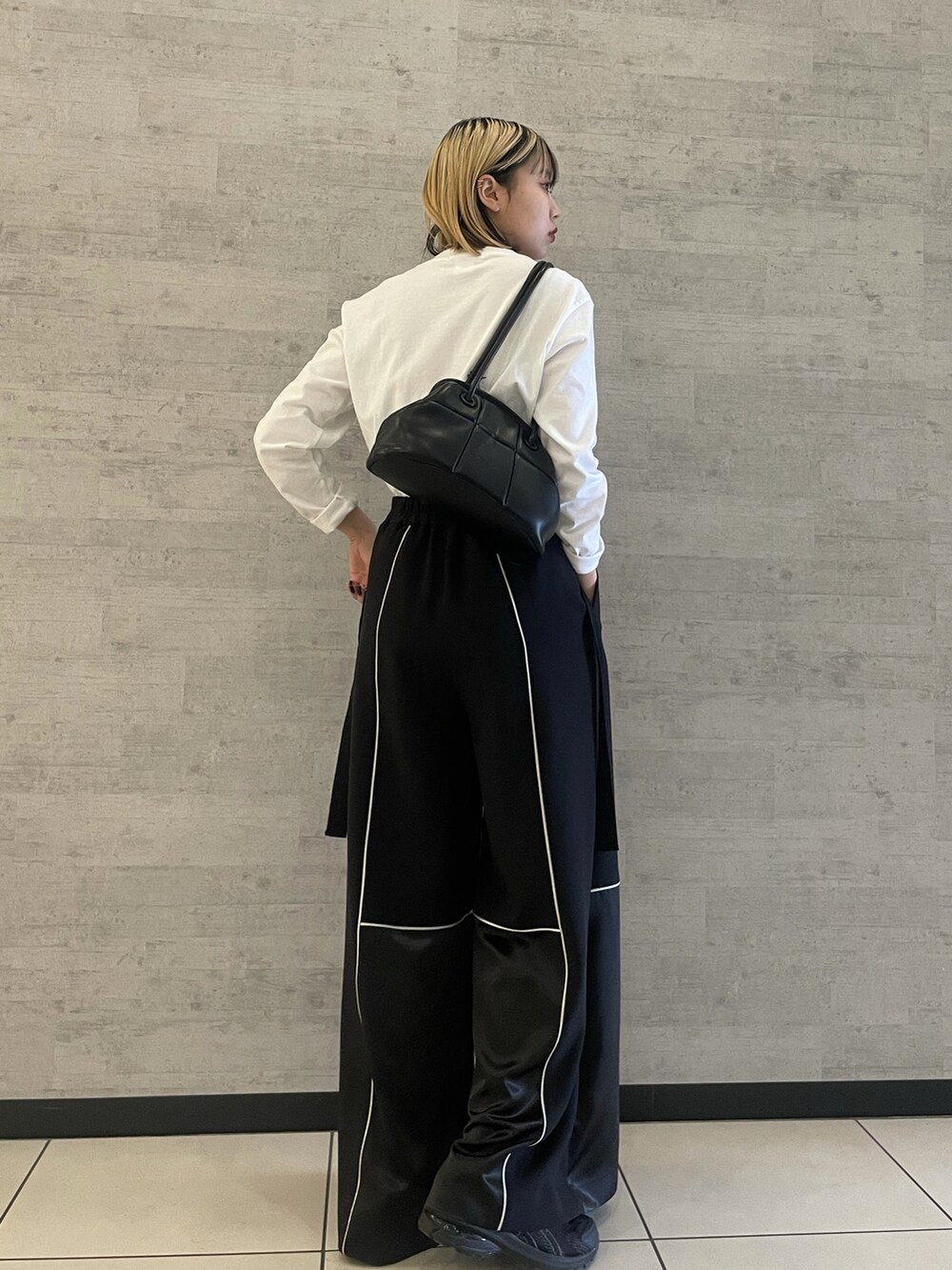 ブラック系のハンドバッグを着用したレディースの冬コーディネートの2枚目の写真