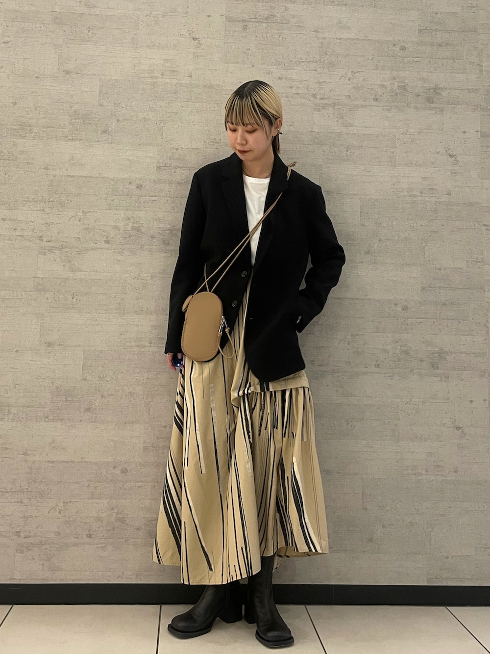 イエロー系のショルダーバッグを着用したレディースの冬コーディネートの2枚目の写真