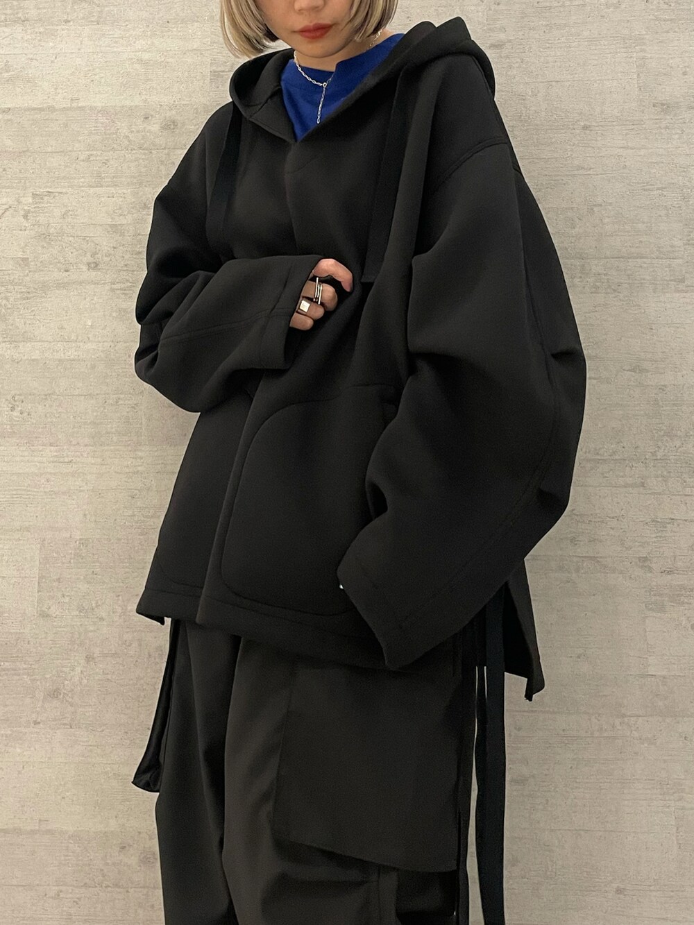 ブラック系のパーカー、ブルー系のカーディガン/ボレロ、ブラック系のカーゴパンツを着用したレディースの冬コーディネートの2枚目の写真