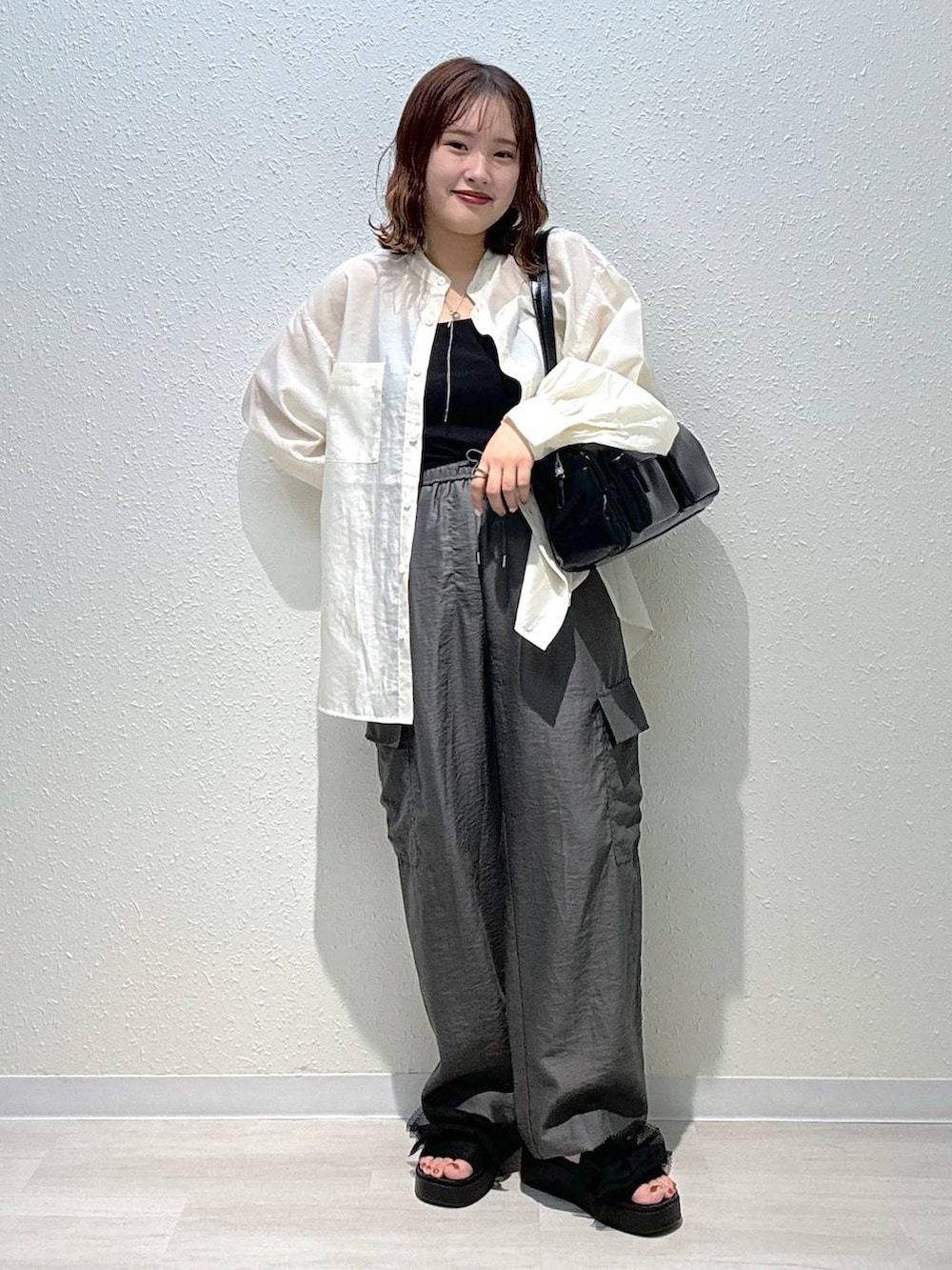 ブラック系のサンダル、グレー系のカーゴパンツ、ブラック系のタンクトップを着用したレディースの夏コーディネートの2枚目の写真