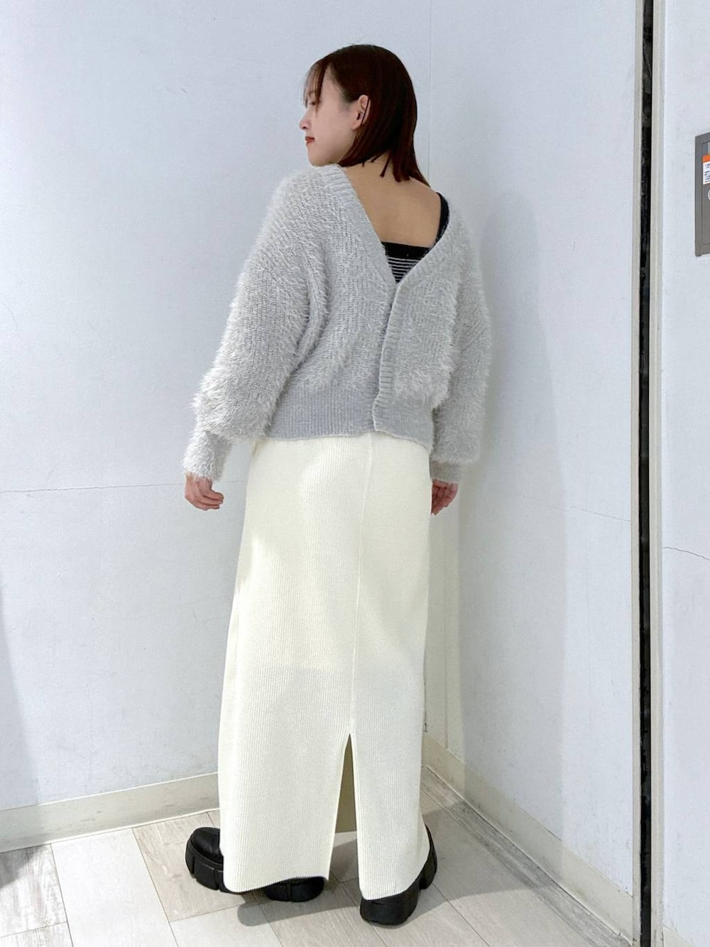 ホワイト系のスカート、ブラック系のブーツ、ホワイト系のブルゾンを着用したレディースの冬コーディネートの4枚目の写真