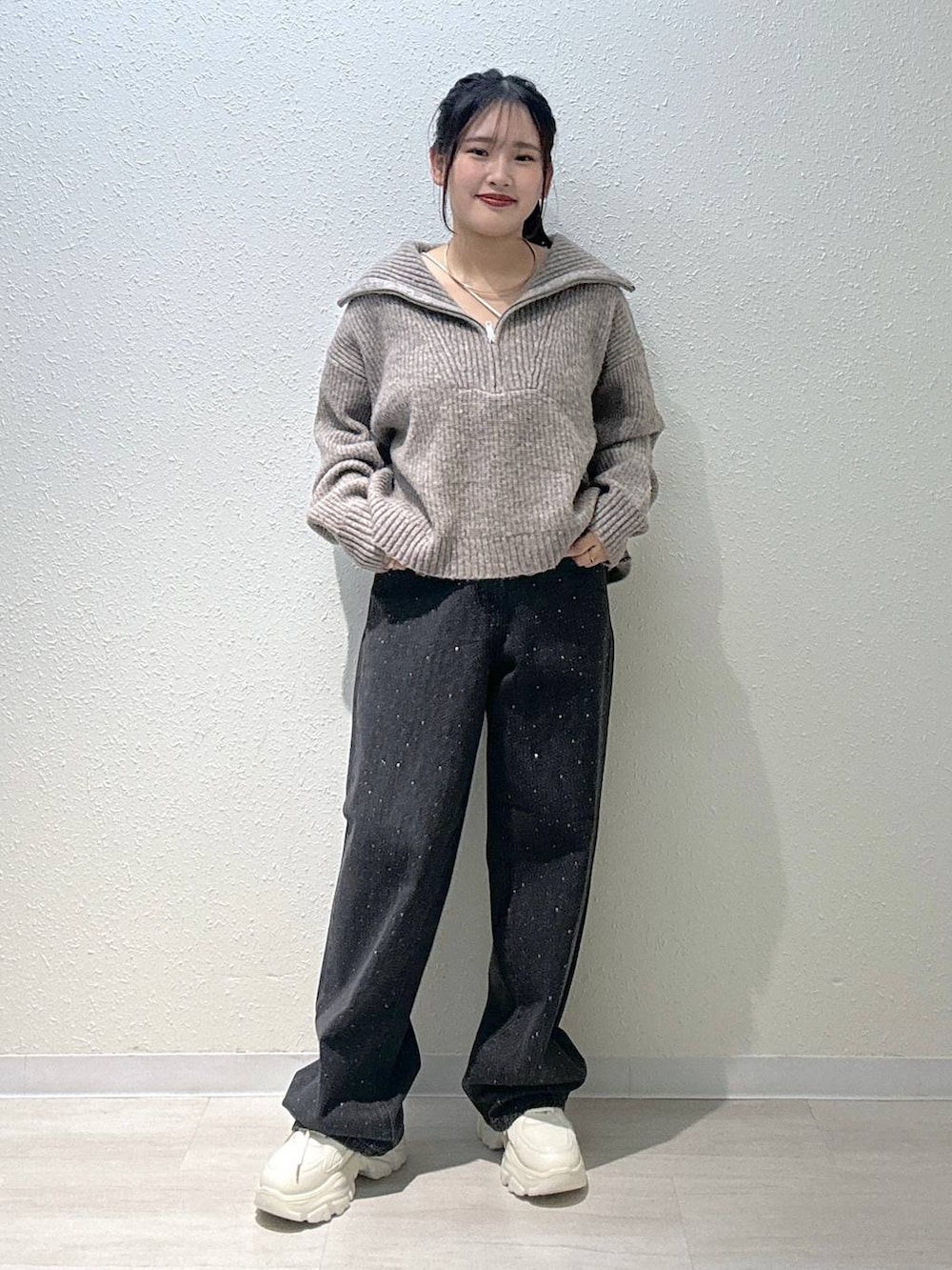 ブラック系のデニムパンツ、ホワイト系のスニーカー、ホワイト系のキャミソールを着用したレディースの秋コーディネートの2枚目の写真