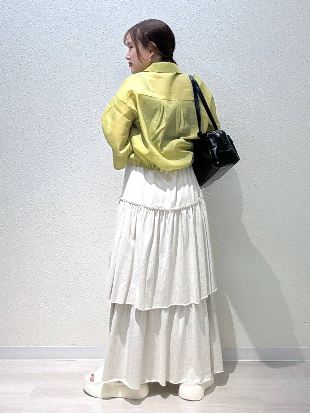 ホワイト系のサンダル、イエロー系のシャツ/ブラウス、ブラック系のボストンバッグを着用したレディースの夏コーディネートの3枚目の写真