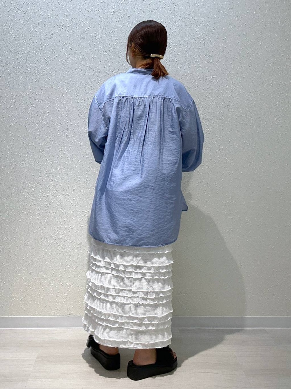 ブラック系のサンダル、ホワイト系のスカート、ブラック系のショルダーバッグを着用したレディースの夏コーディネートの3枚目の写真