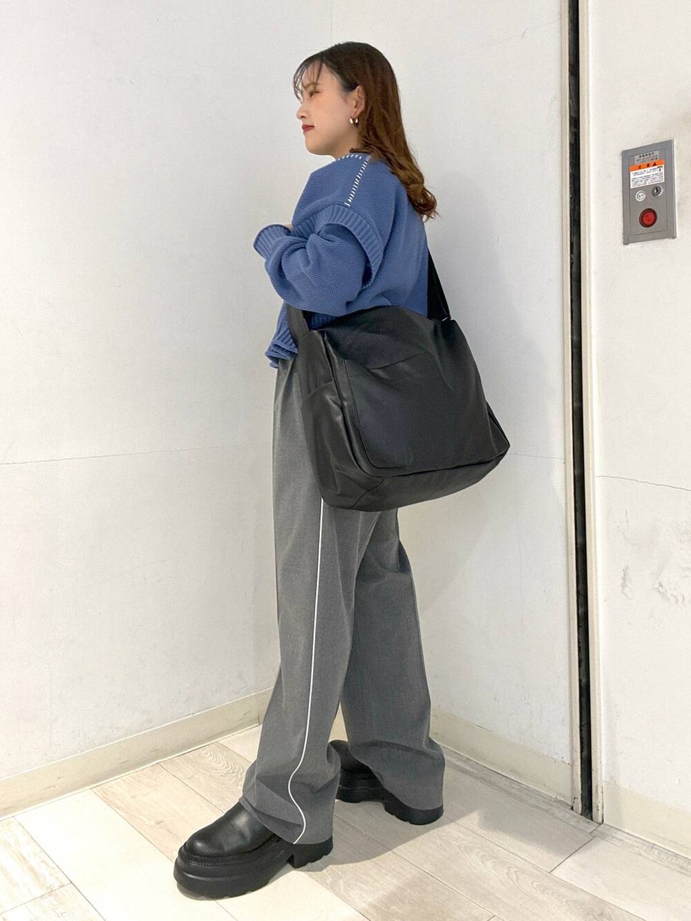 ブラック系のボディバッグ/ウエストポーチ、グレー系のその他パンツ、ブルー系のTシャツ/カットソーを着用したレディースの冬コーディネートの2枚目の写真