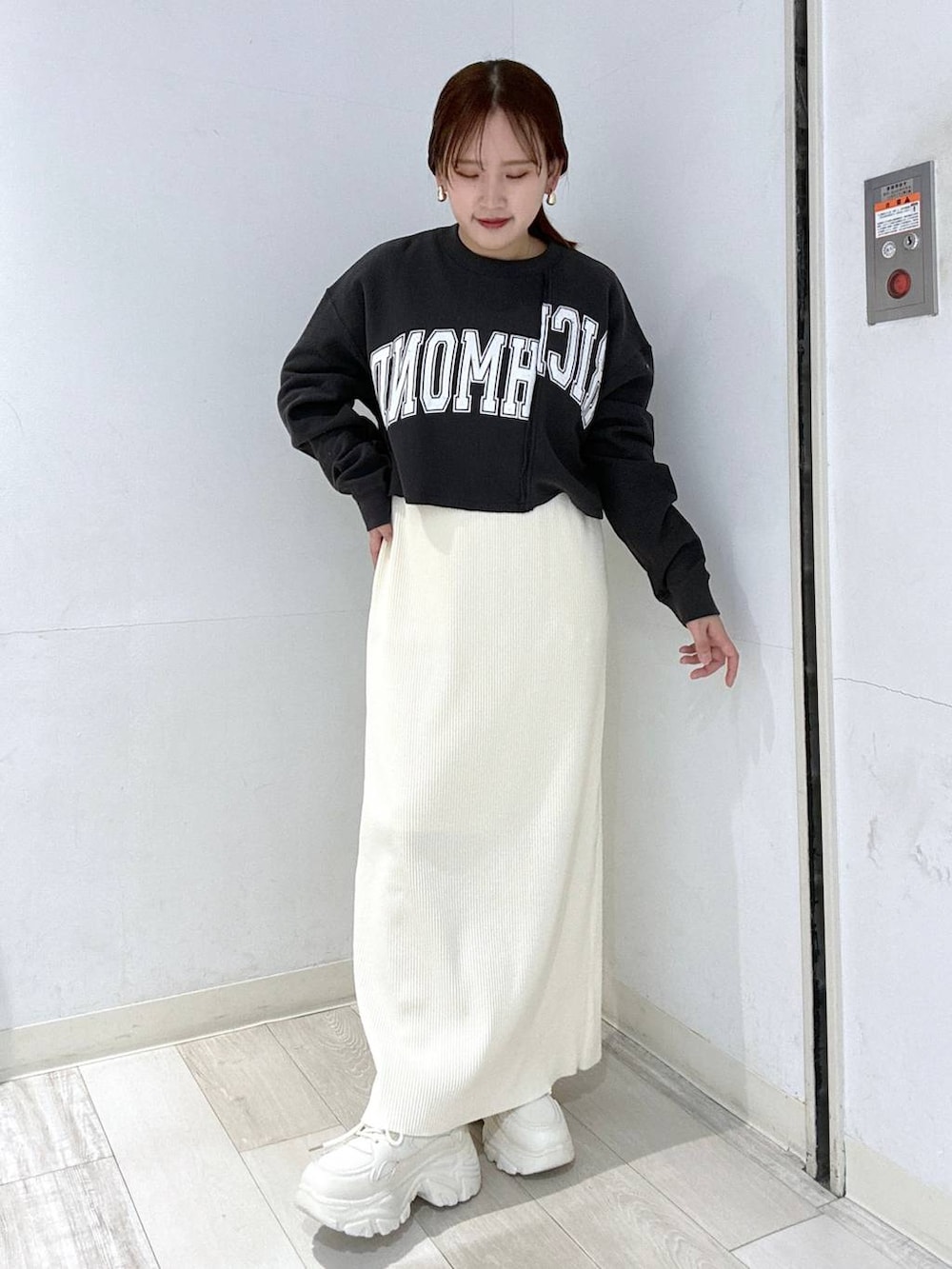 ホワイト系のスカート、ブラック系のブルゾン、ホワイト系のスニーカーを着用したレディースの冬コーディネートの4枚目の写真