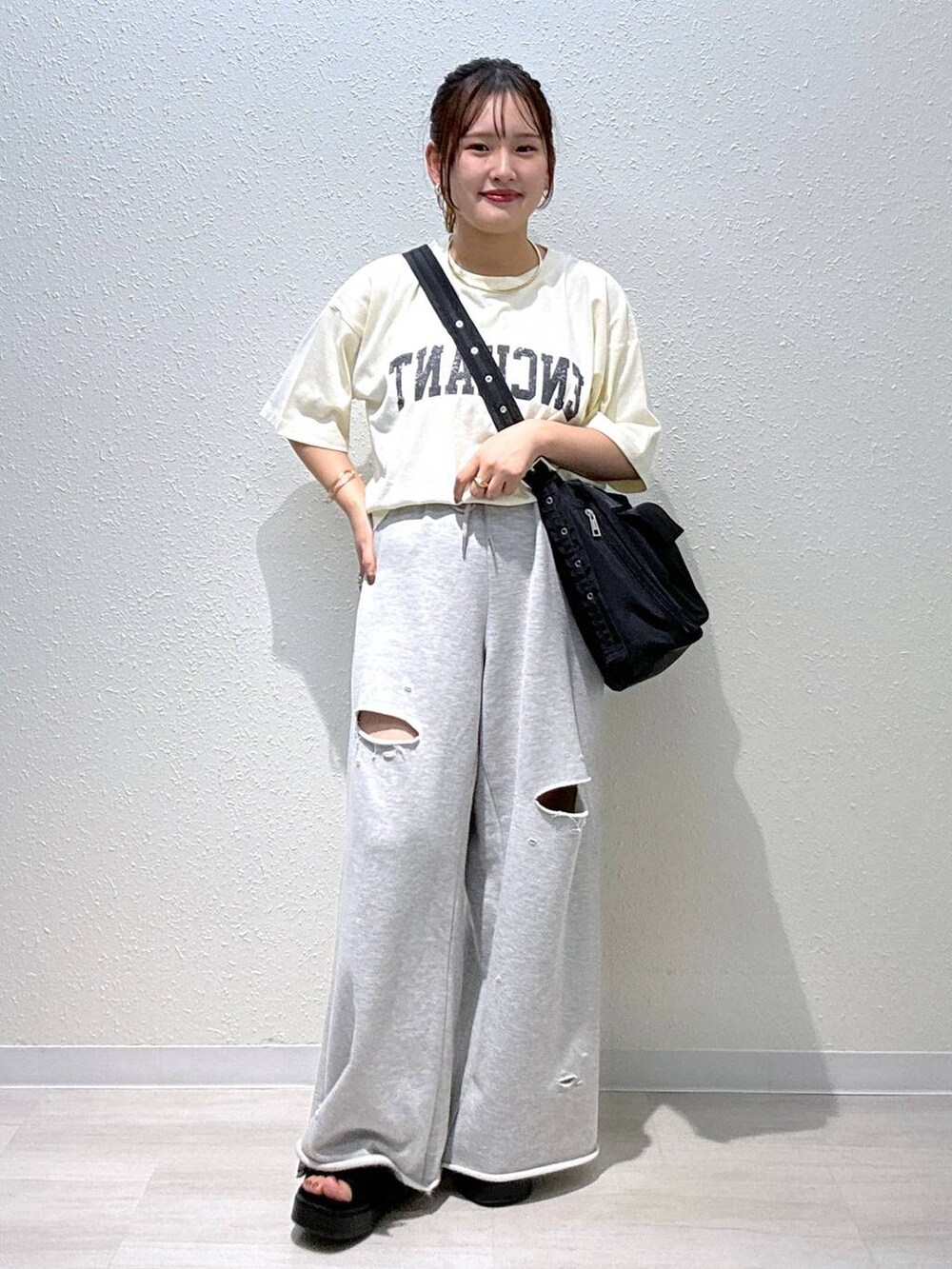 ブラック系のサンダル、ホワイト系のTシャツ/カットソー、ブラック系のショルダーバッグを着用したレディースの夏コーディネートの2枚目の写真