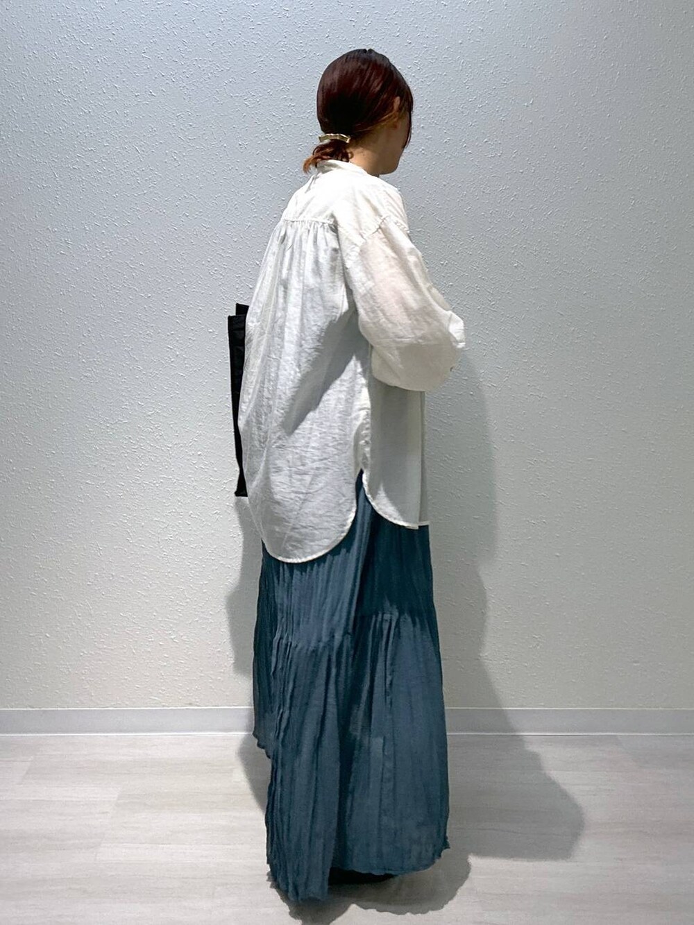 ブラック系のサンダル、ブラック系のトートバッグ、ブルー系のワンピースを着用したレディースの夏コーディネートの2枚目の写真