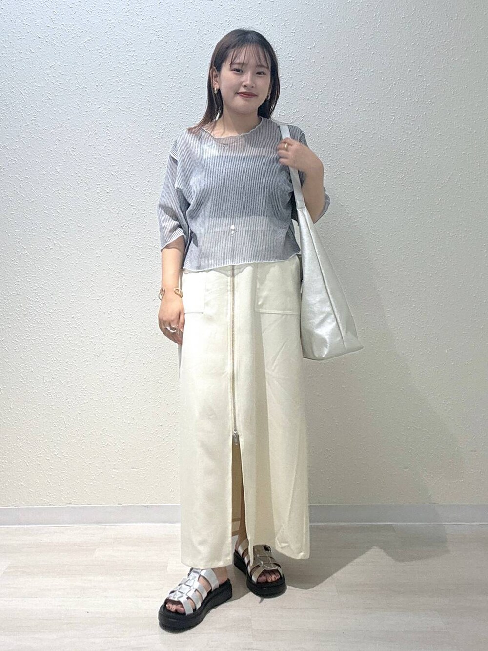 シルバー系のショルダーバッグ、シルバー系のスニーカー、グレー系のTシャツ/カットソーを着用したレディースの秋コーディネートの2枚目の写真