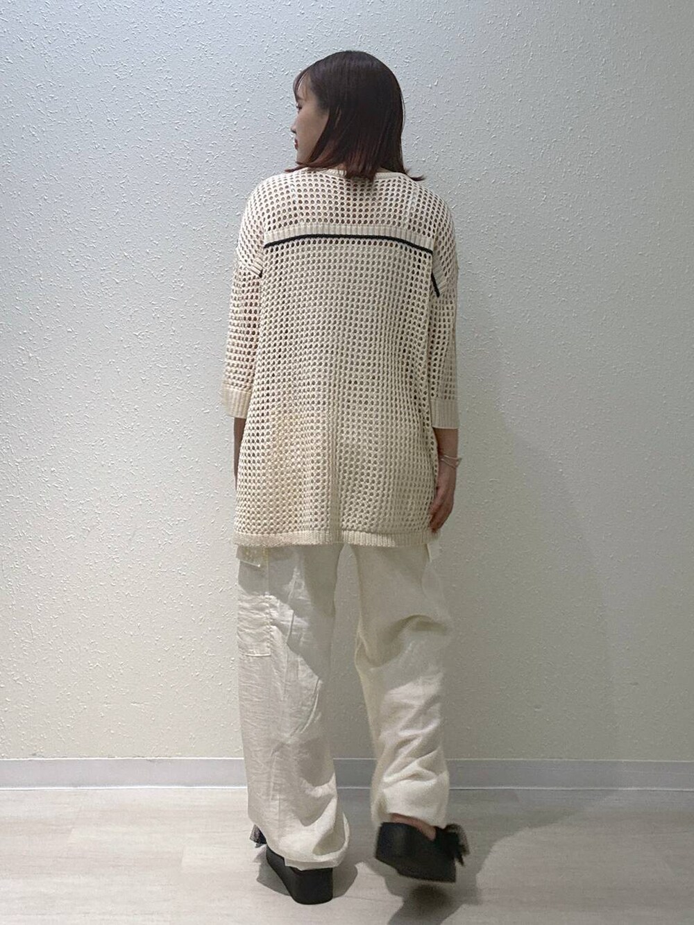 ブラック系のサンダル、ホワイト系のカーゴパンツ、ホワイト系のニット/セーターを着用したレディースの夏コーディネートの3枚目の写真