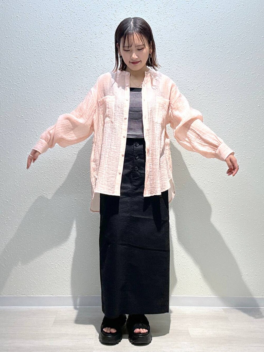 ブラック系のスカート、ブラック系のタンクトップ、ピンク系のシャツ/ブラウスを着用したレディースの春コーディネートの2枚目の写真