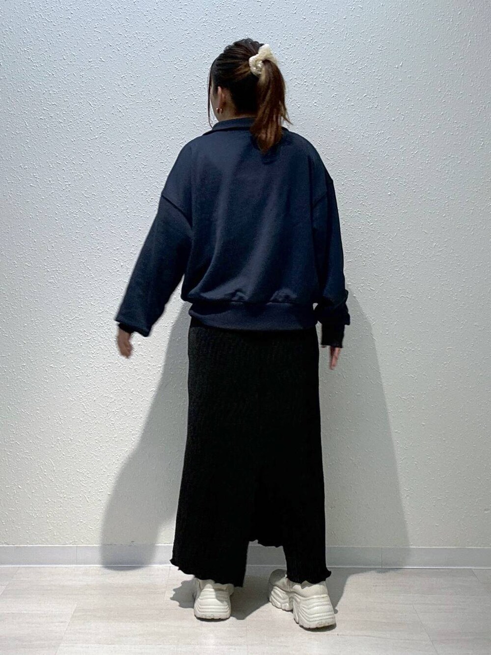 ブルー系のスウェット、ホワイト系のブーツ、ブラック系のスカートを着用したレディースの秋コーディネートの3枚目の写真