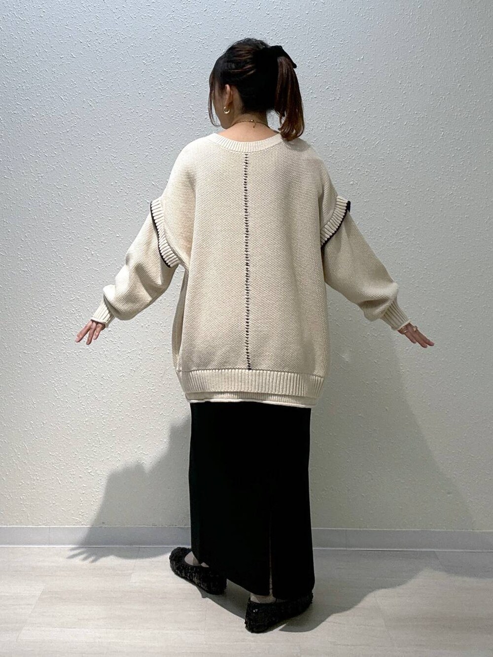 ホワイト系のニット/セーター、ブラック系のスカート、ブラック系のバレエシューズを着用したレディースの秋コーディネートの4枚目の写真