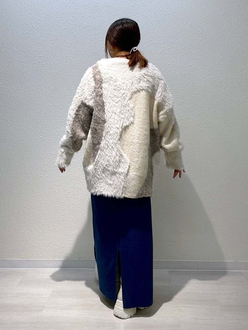 ブルー系のスカート、ホワイト系のカーディガン/ボレロ、ホワイト系のブーツを着用したレディースの秋コーディネートの4枚目の写真