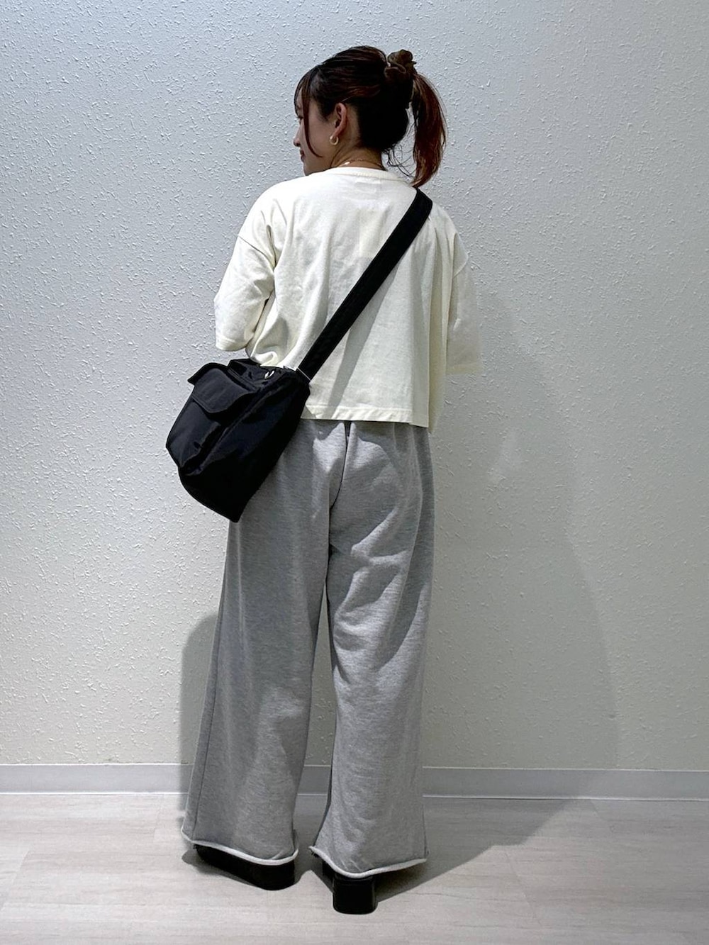 ブラック系のサンダル、ホワイト系のTシャツ/カットソー、ブラック系のショルダーバッグを着用したレディースの夏コーディネートの3枚目の写真