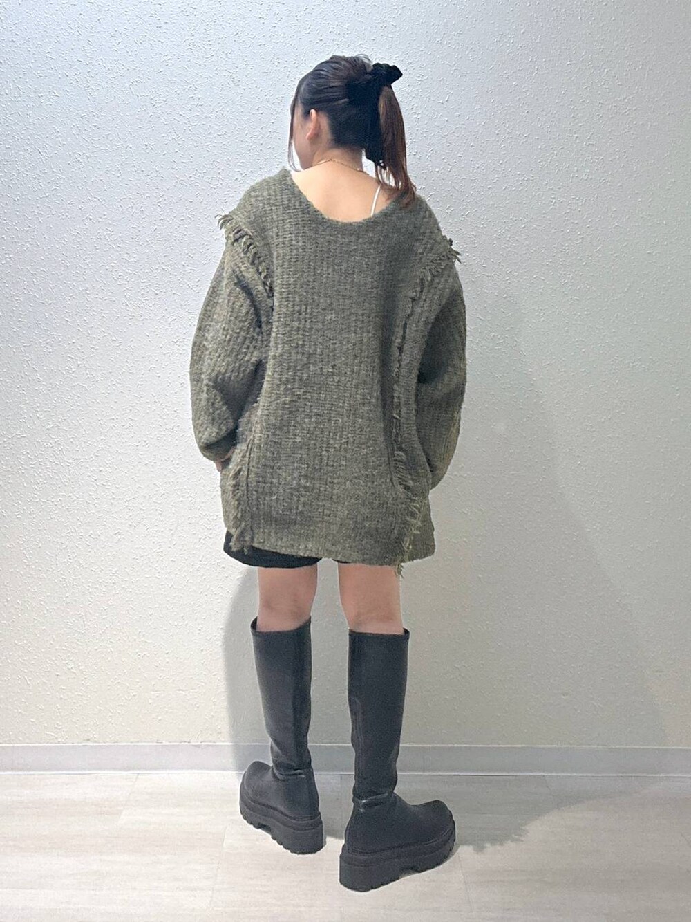 グリーン系のニット/セーター、ブラック系のその他パンツ、ホワイト系のキャミソールを着用したレディースの秋コーディネートの3枚目の写真