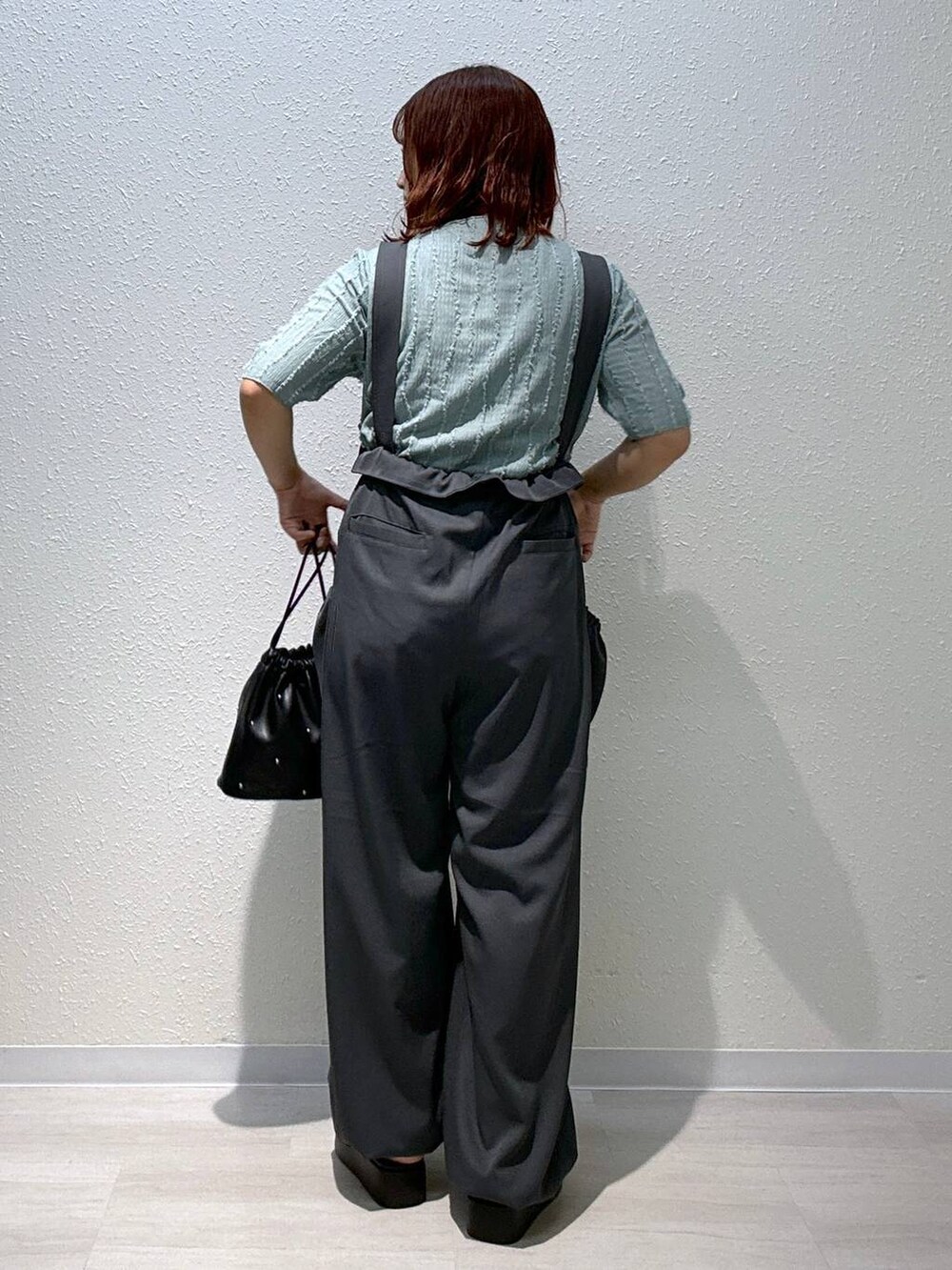 ブラック系のショルダーバッグ、シルバー系のサンダル、グリーン系のTシャツ/カットソーを着用したレディースの秋コーディネートの4枚目の写真
