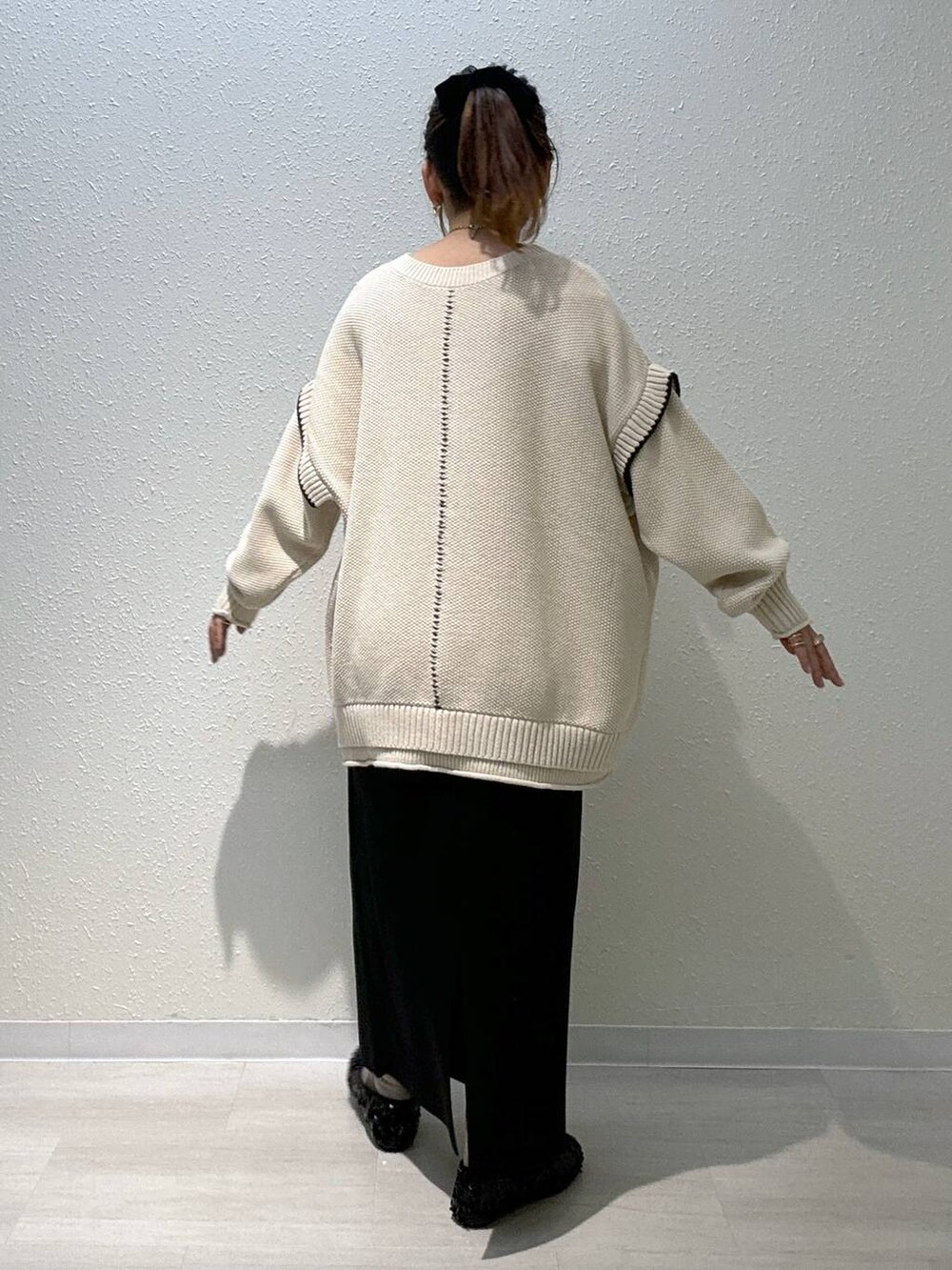 ホワイト系のニット/セーター、ブラック系のスカート、ブラック系のバレエシューズを着用したレディースの秋コーディネートの3枚目の写真