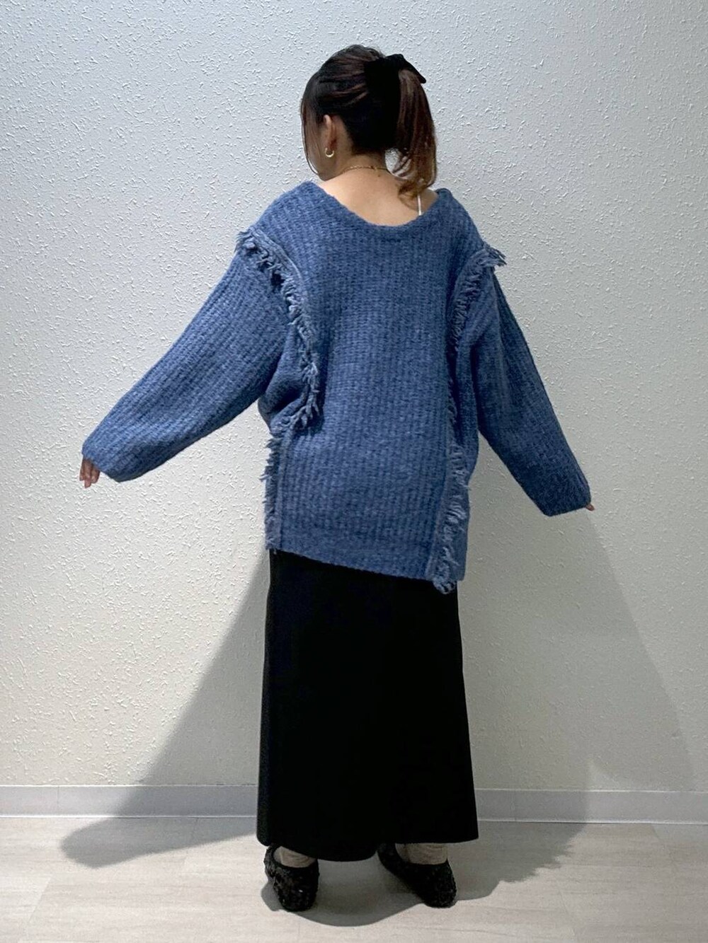 ブルー系のニット/セーター、ブラック系のバレエシューズ、ホワイト系のキャミソールを着用したレディースの秋コーディネートの4枚目の写真