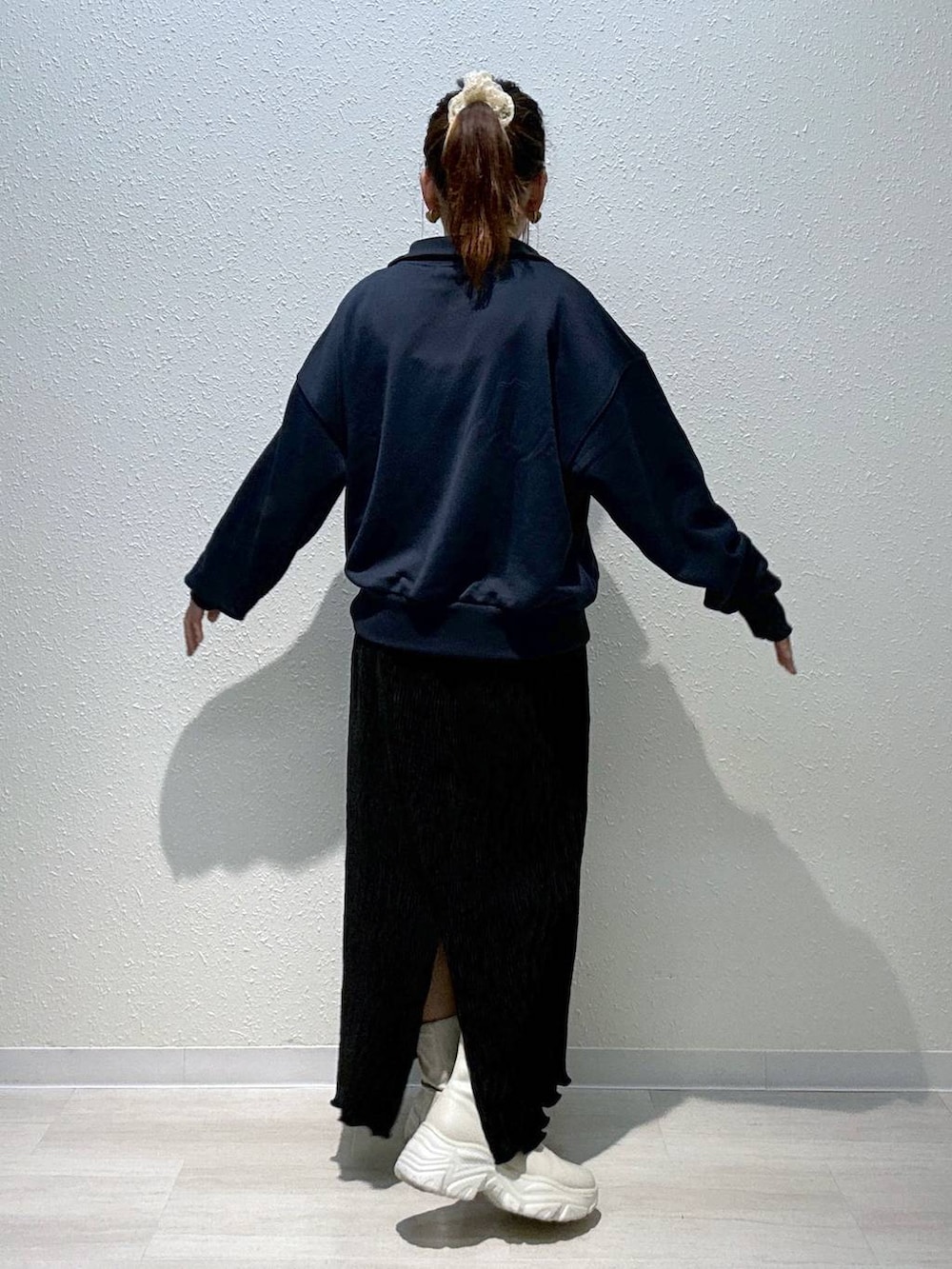 ブルー系のスウェット、ホワイト系のブーツ、ブラック系のスカートを着用したレディースの秋コーディネートの2枚目の写真