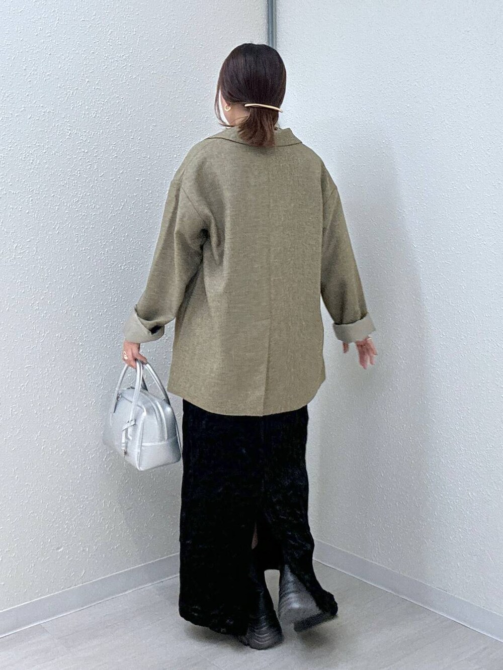 ブラウン系のテーラードジャケット、ブラック系のブーツ、ブラック系のキャミソールを着用したレディースの秋コーディネートの3枚目の写真