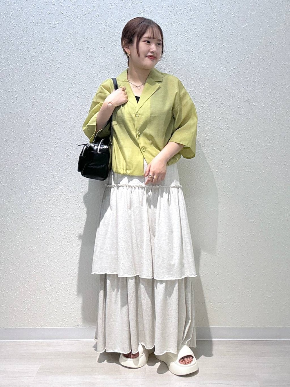 ホワイト系のサンダル、イエロー系のシャツ/ブラウス、ブラック系のボストンバッグを着用したレディースの夏コーディネートの2枚目の写真