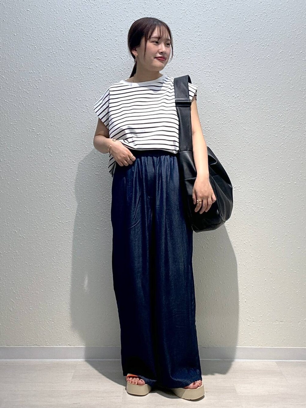 ベージュ系のサンダル、ブラック系のボディバッグ/ウエストポーチ、ブルー系のデニムパンツを着用したレディースの夏コーディネートの2枚目の写真