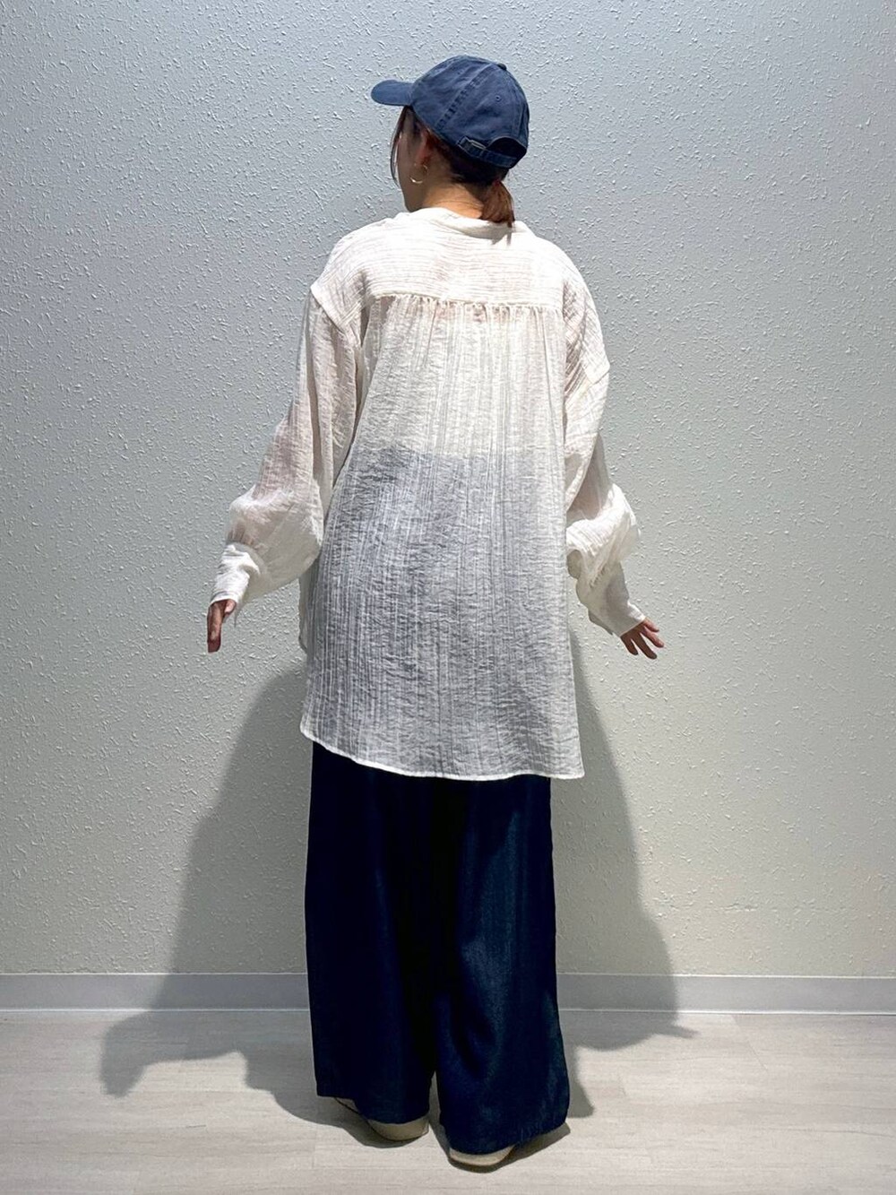 ベージュ系のサンダル、ホワイト系のシャツ/ブラウス、ブルー系のデニムパンツを着用したレディースの夏コーディネートの3枚目の写真