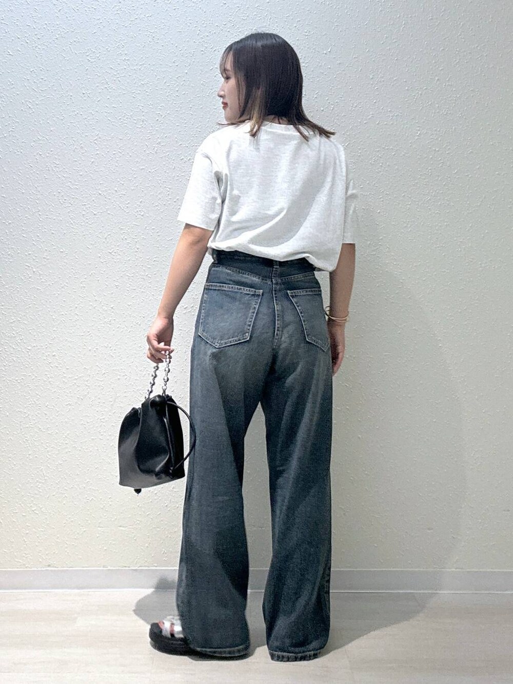 ブラック系のショルダーバッグ、グレー系のTシャツ/カットソー、ブルー系のデニムパンツを着用したレディースの夏コーディネートの3枚目の写真