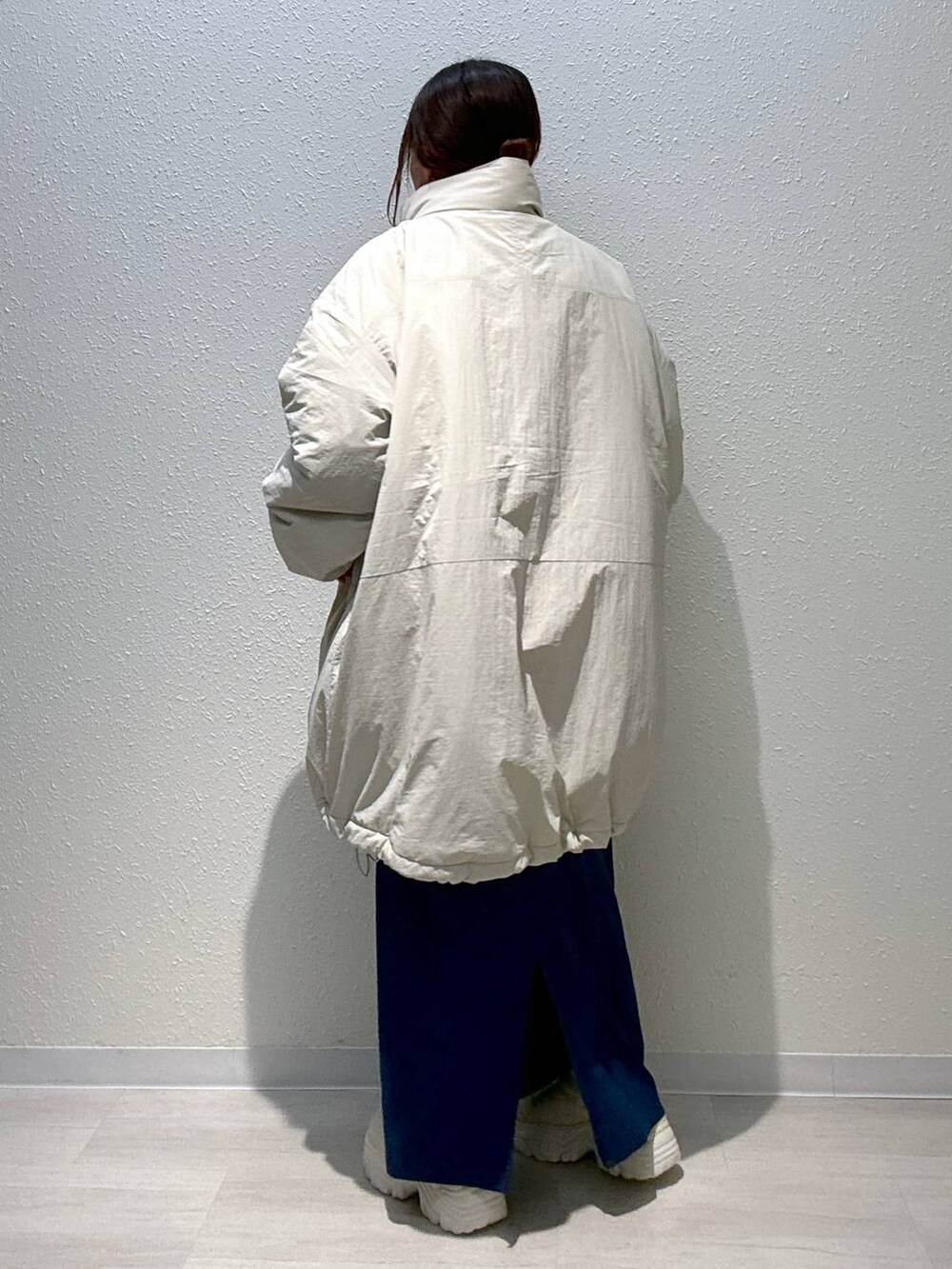 ブルー系のスカート、ホワイト系のその他アウター、ホワイト系のブーツを着用したレディースの秋コーディネートの4枚目の写真