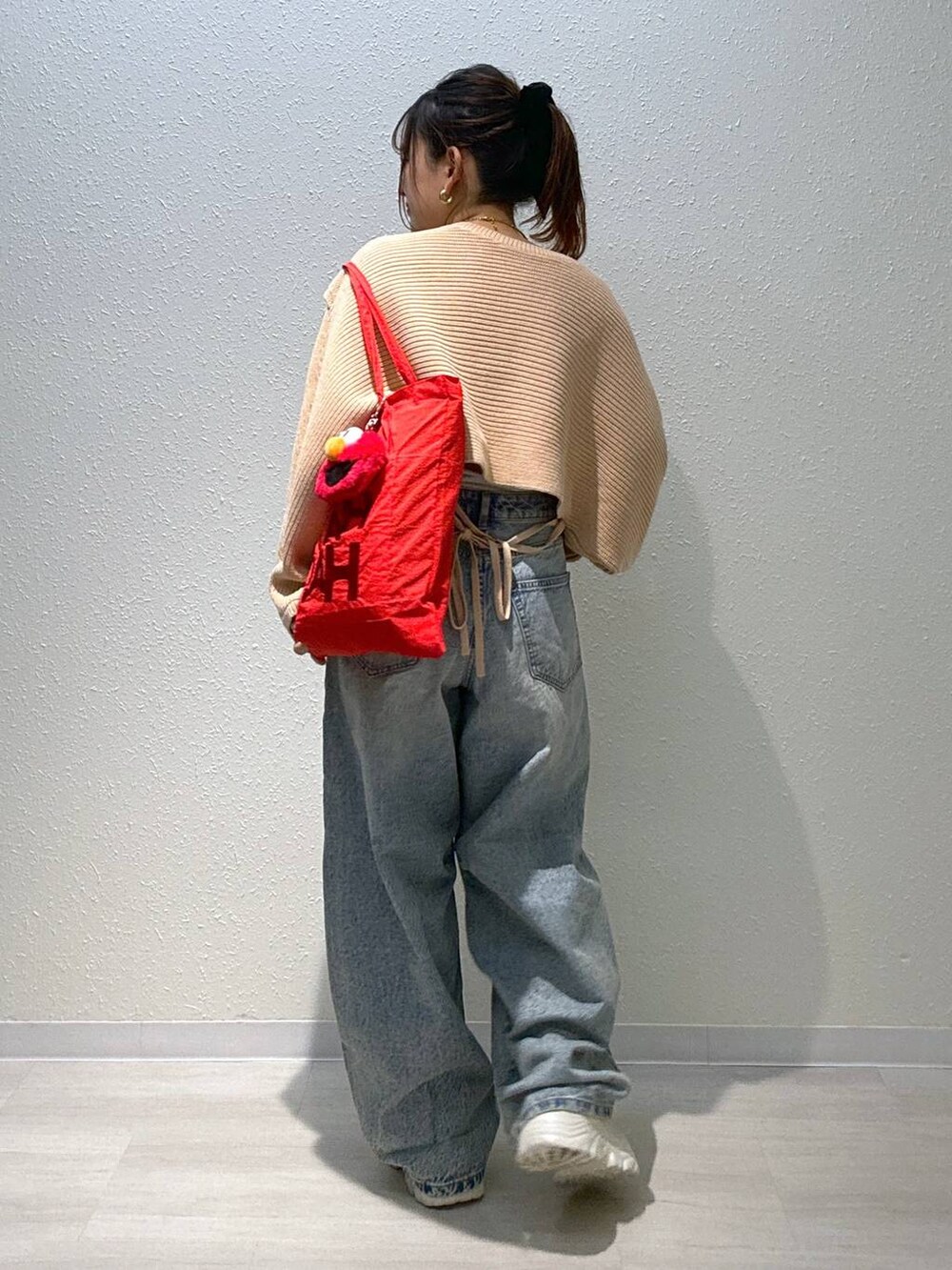 ブルー系のデニムパンツ、ホワイト系のキャミソール、ホワイト系のブーツを着用したレディースの秋コーディネートの2枚目の写真