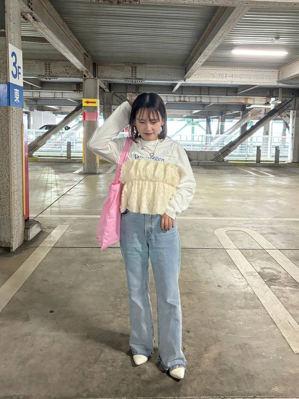 ピンク系のトートバッグ、ブルー系のデニムパンツ、ホワイト系のリングを着用したレディースの春コーディネートの4枚目の写真