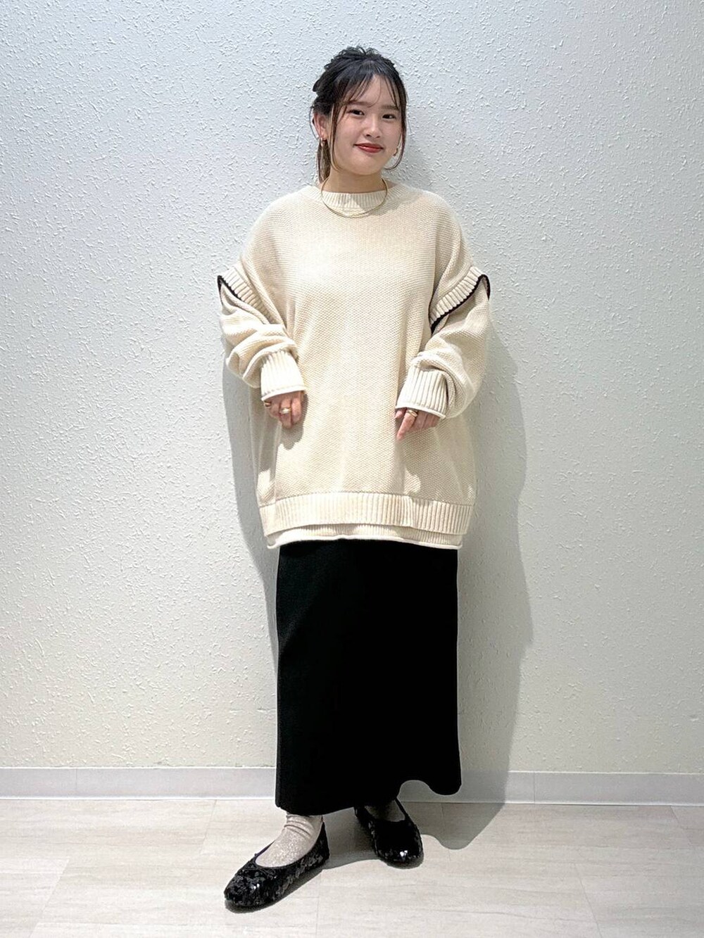 ホワイト系のニット/セーター、ブラック系のスカート、ブラック系のバレエシューズを着用したレディースの秋コーディネートの2枚目の写真