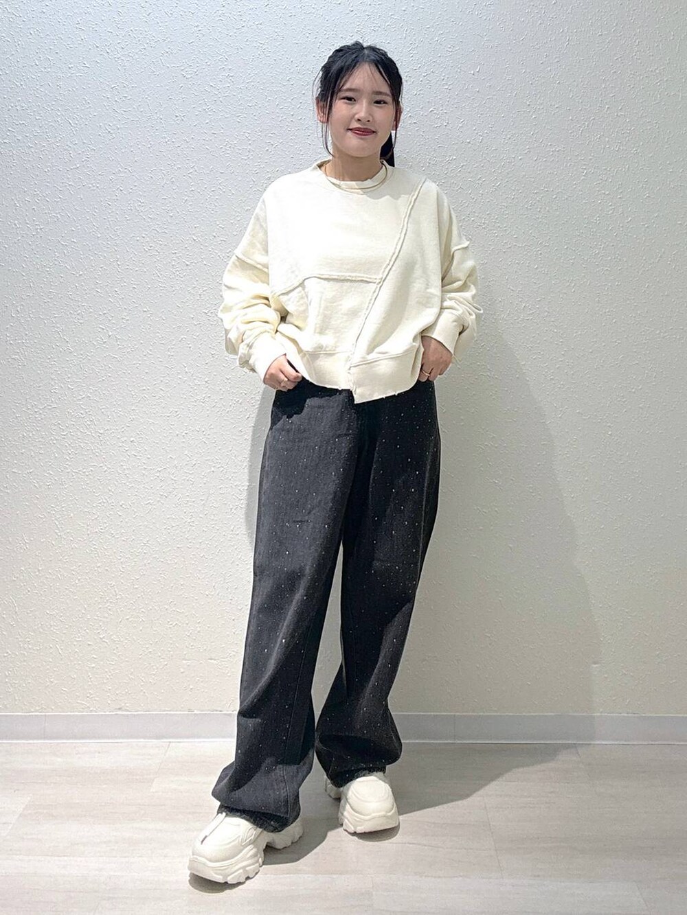 ホワイト系のスニーカー、ホワイト系のスウェット、ブラック系のデニムパンツを着用したレディースの秋コーディネートの2枚目の写真