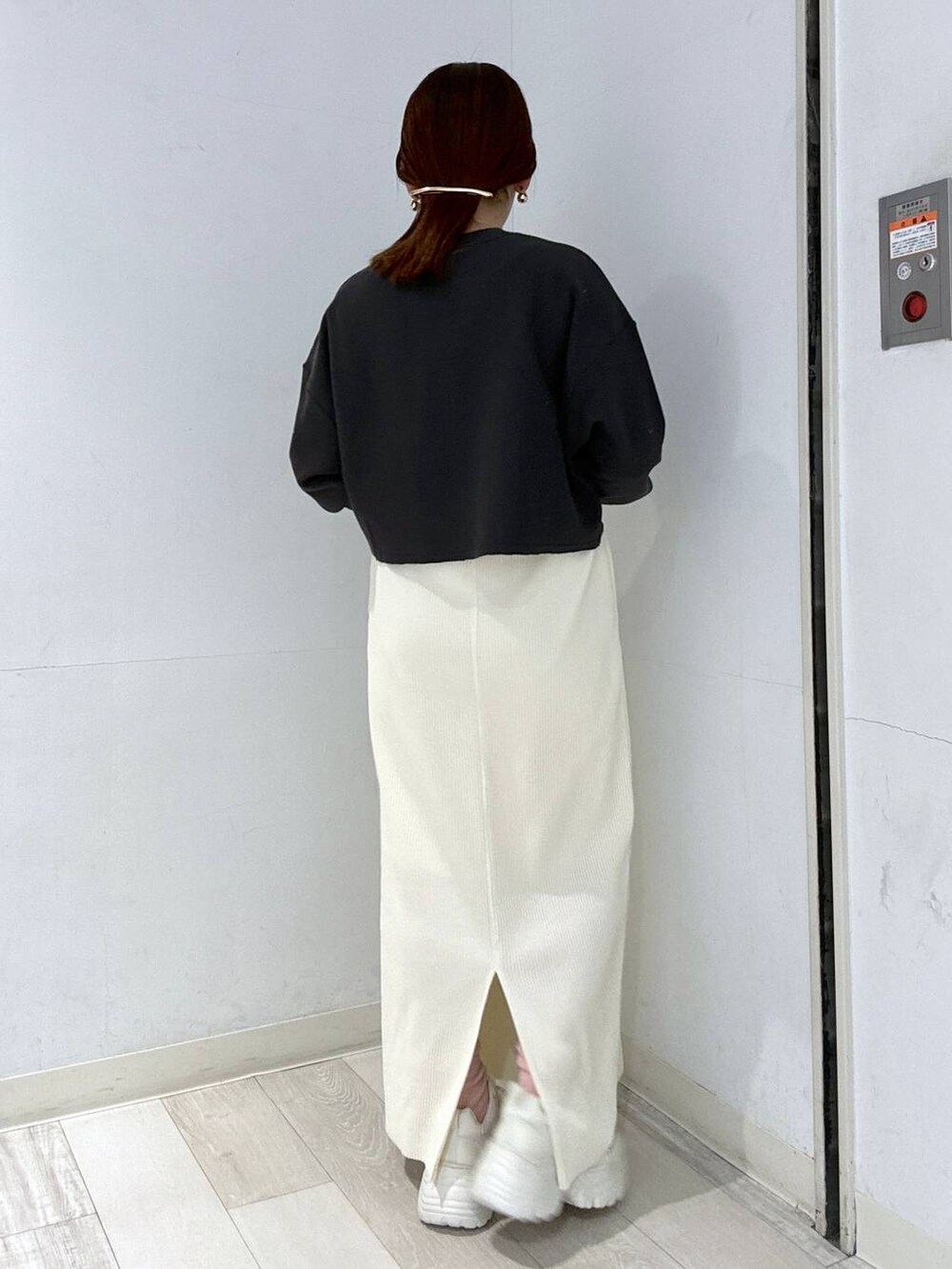 ホワイト系のスカート、ブラック系のブルゾン、ホワイト系のスニーカーを着用したレディースの冬コーディネートの5枚目の写真