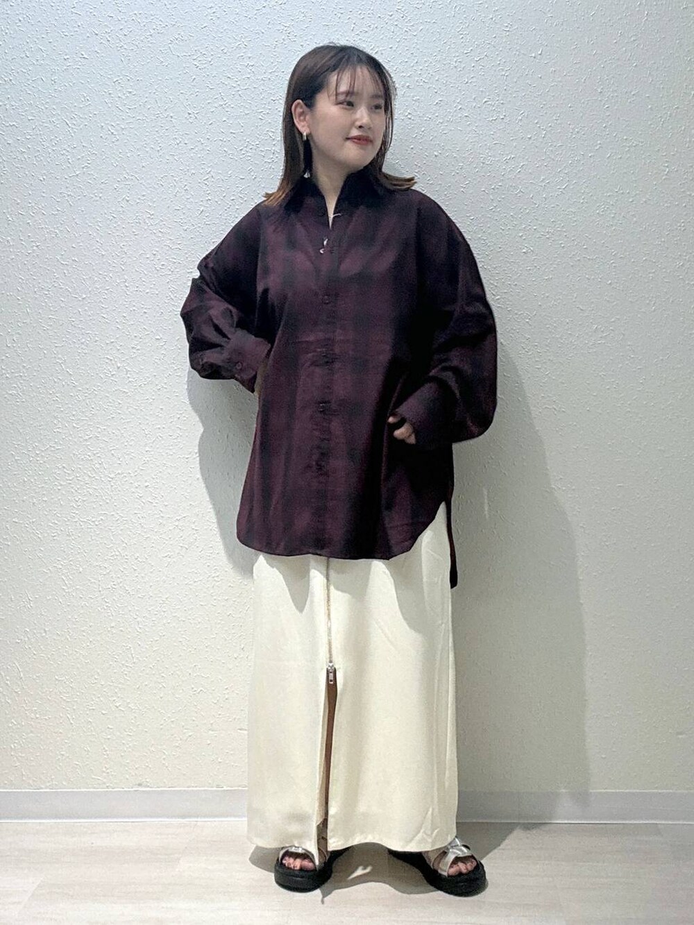 レッド系のシャツ/ブラウス、シルバー系のスニーカー、ホワイト系のスカートを着用したレディースの秋コーディネートの2枚目の写真