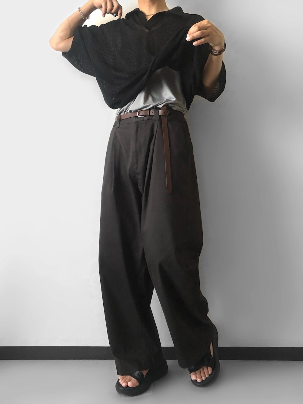 ブラック系のポロシャツ、グレー系のその他パンツ、ブラック系のサンダルを着用したメンズの夏コーディネートの3枚目の写真