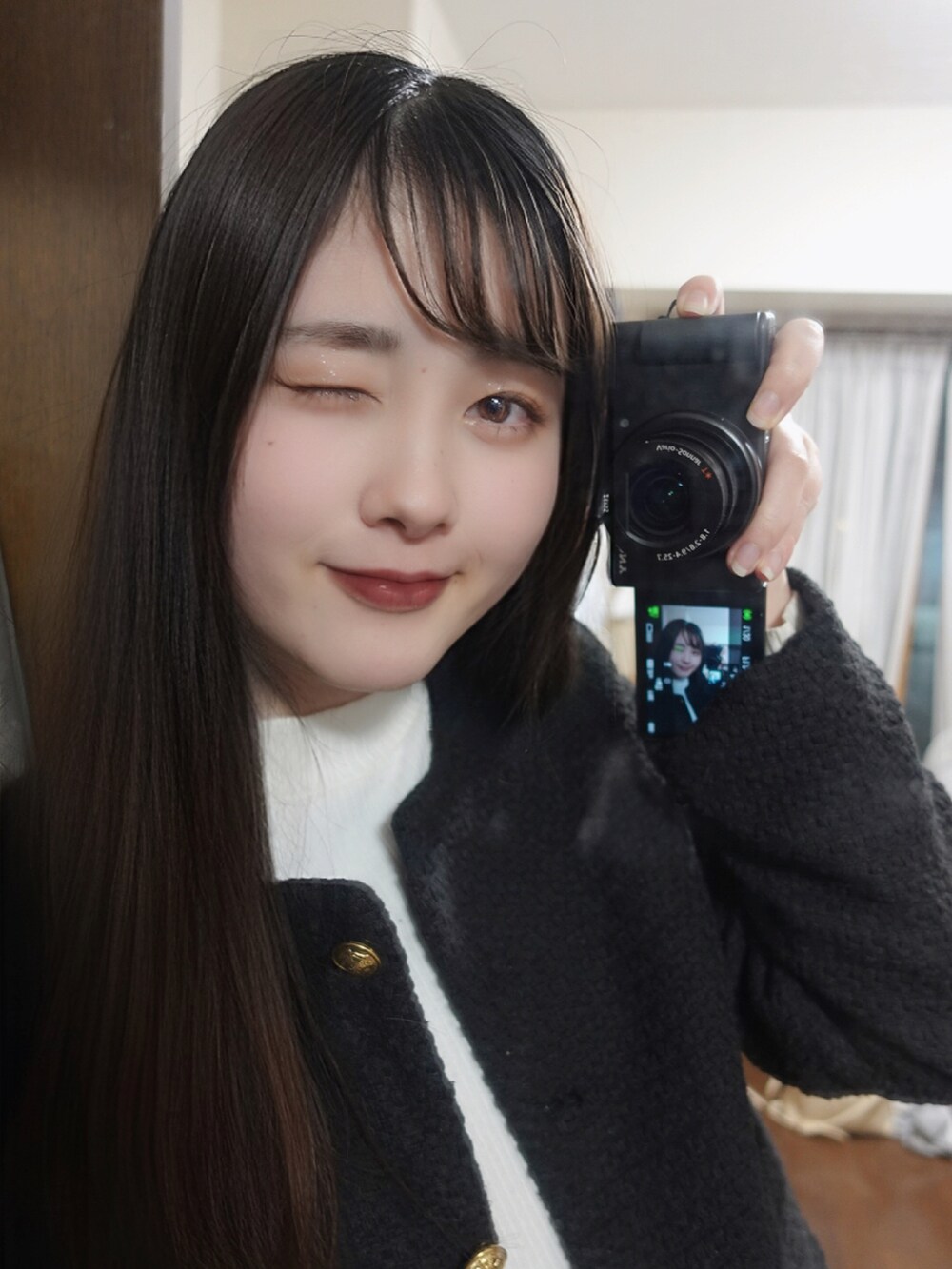 ブラック系のノーカラージャケット、ホワイト系のニット/セーターを着用したレディースの秋コーディネートの2枚目の写真