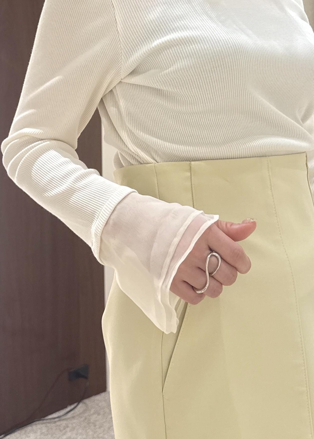 ホワイト系のハンドバッグ、ベージュ系のスカート、ブルー系のデニムジャケットを着用したレディースの春コーディネートの5枚目の写真