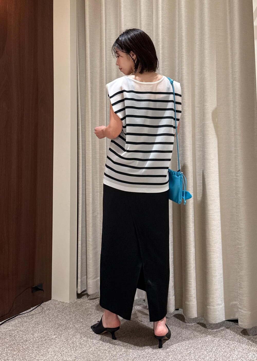 ブラック系のサンダル、ブラック系のスカート、ブルー系のシャツ/ブラウスを着用したレディースの夏コーディネートの3枚目の写真