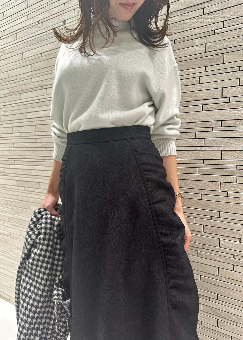 ホワイト系のブーツ、ベージュ系のショルダーバッグ、グリーン系のニット/セーターを着用したレディースの冬コーディネートの5枚目の写真