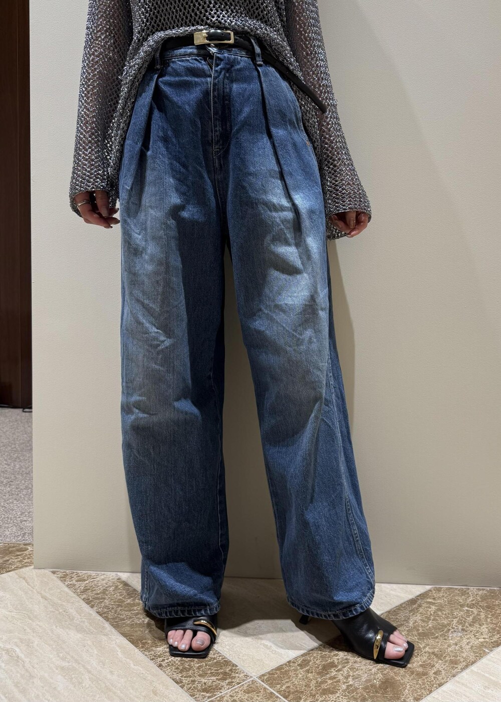 ブルー系のデニムパンツ、ブラック系のサンダル、シルバー系のその他トップスを着用したレディースの春コーディネートの5枚目の写真