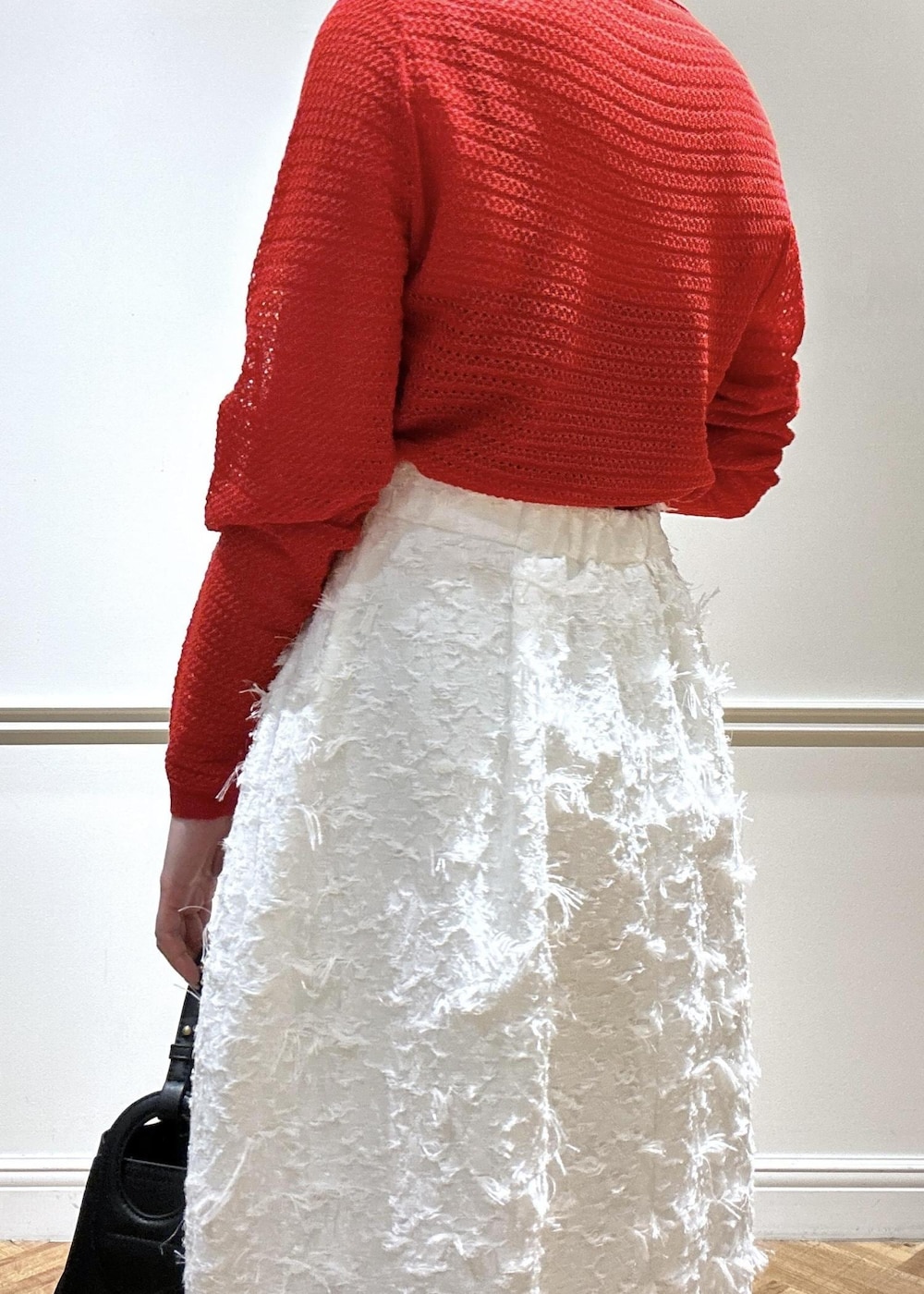 ブラック系のショルダーバッグ、ブラック系のパンプス、ホワイト系のスカートを着用したレディースの春コーディネートの6枚目の写真