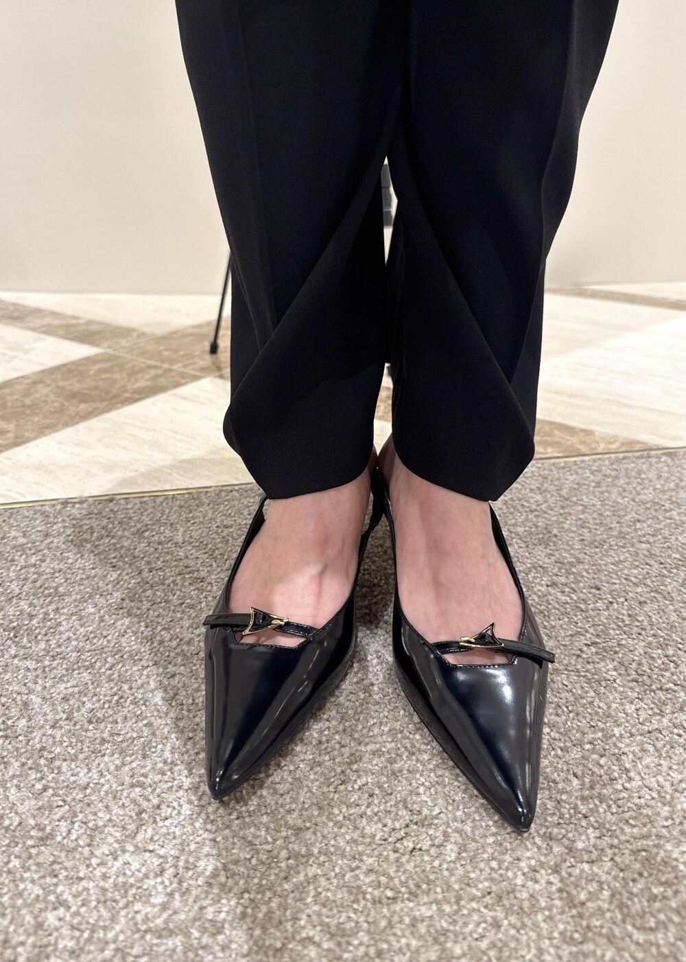 ブラック系のパンプス、グリーン系のトートバッグ、ブラック系のシャツ/ブラウスを着用したレディースの夏コーディネートの6枚目の写真